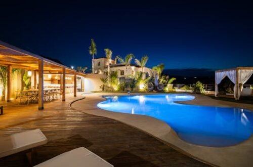Experience luxury in a Mediterranean villa poolside at night, perfect for relaxation.