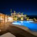 Experience luxury in a Mediterranean villa poolside at night, perfect for relaxation.