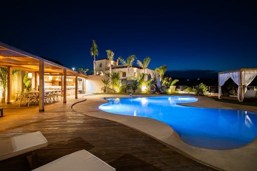 Experience luxury in a Mediterranean villa poolside at night, perfect for relaxation.